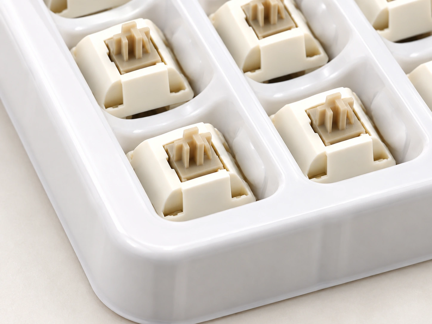 Close-up of Xuhua Doll switches beside the edge of a white tray