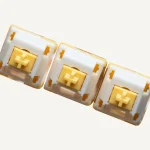Three actual QVQ N2 Milk Dragon V2 switch samples with yellow stems and light guides.