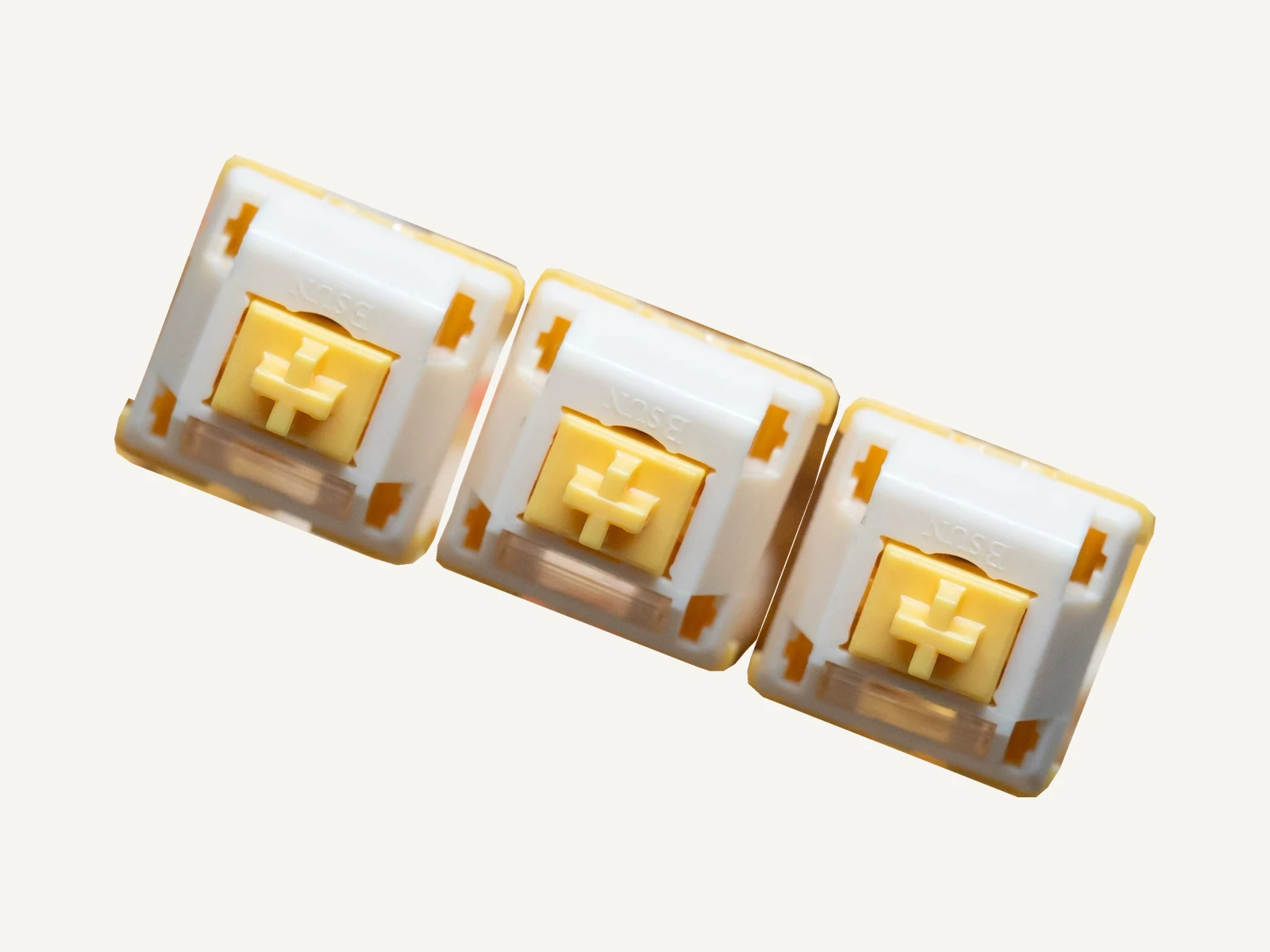Three actual QVQ N2 Milk Dragon V2 switch samples with yellow stems and light guides.